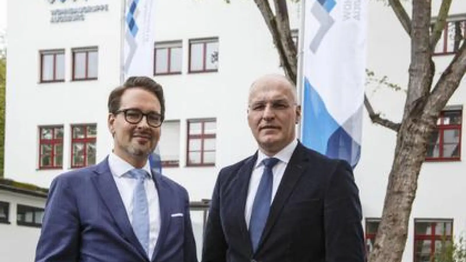 Mit neuem Logo im Hintergrund:    Mark Dominik Hoppe (links) und Oberbürgermeister Kurt Gribl vor der Geschäftsstelle der Wohnbaugruppe Augsburg.	Foto: Bernd Jaufmann (Foto: Bernd Jaufmann)