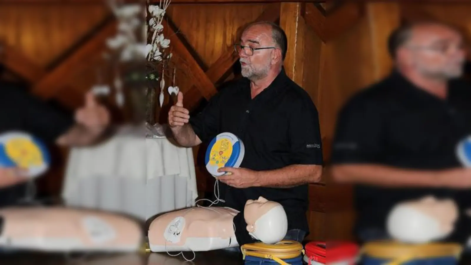 Volker Brand  mit Puppe und angeschlossenem Trainings-Defibrillator. 	Foto: Mokosch (Foto: Mokosch)