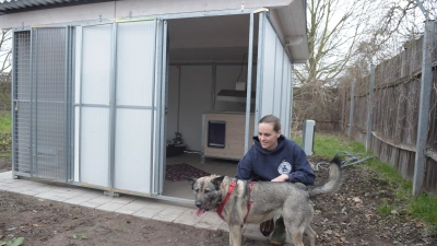 Bonita und Tierpflegerin Joana Müller freuen sich über die neue Hundebox, die aus der Spende finanziert wird. (Foto: Fred Schöllhorn / Stadtsparkasse Augsburg)