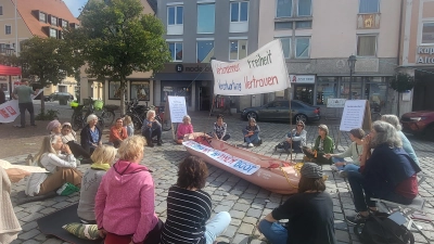 <b>Rund 25 Frauen</b> und Männer setzten am Samstag auf dem Stadtplatz ein Zeichen für Werte wie Vertrauen, Verantwortung und Freiheit. Mit ihrer Aktion wollen sie darauf aufmerksam machen, dass „wir alle in einem Boot sitzen”. (Foto: Alina Seitz)