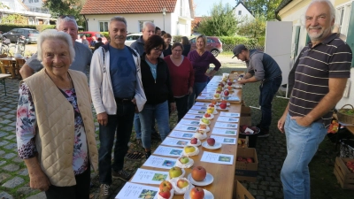 <b>Uwe Schäfer</b> (vorne rechts) präsentierte den Festgästen eine Riesenauswahl an Äpfeln. (Foto: [osj] (presse@ainhofen.de, Josef Ostermair))