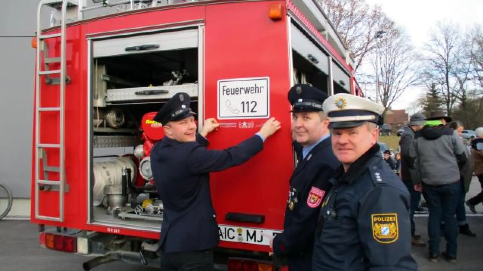 Dominik Birkmeir,   Kommandant Manfred Walch und Polizeihauptkommissar Hannes Stiegler (von links) bringen den Aufkleber am Feuerwehrauto an. Die Feuerwehr Inchenhofen gehört zum #TeamRettungsgasse und unterstützt die Social-Media-Kampagne des Polizeipräsidiums Schwaben-Nord.