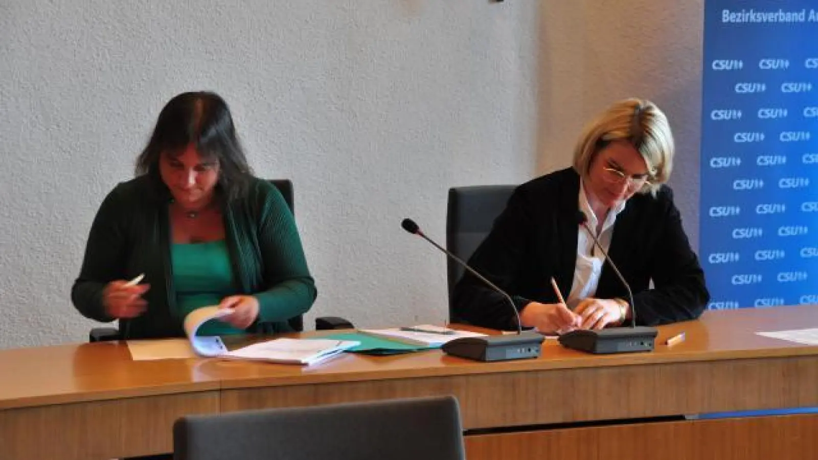 Martina Wild   (Grüne, Links) und Eva Weber (CSU) unterzeichnen den Koalitionsvertrag.	Fotos: Laura Türk (Fotos: Laura Türk)