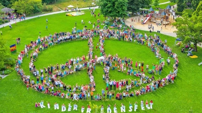Besucher des Kinderfriedensfestes bilden das „Lebende Friedenszeichen”. (Archivfoto: Christian Menkel / Stadt Augsburg)