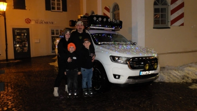 <b>Bereit für die „Lichterausfahrt”:</b>Melanie und Florian Ziegler mit dem siebenjährigen Julian (links) und dem neunjährigen Jonas vor ihrem beleuchteten Pickup. (Foto: Nayra Weber)