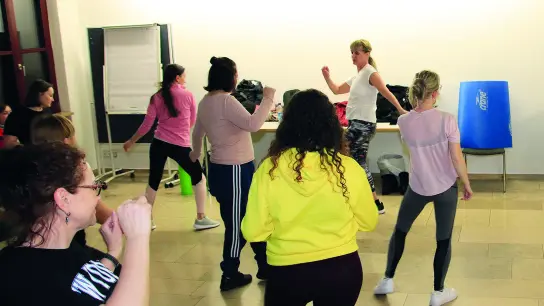 Die Tanzlehrerin Andra Bader aus Mering (vorne Mitte) hat den 20 Frauen aus der Ukraine einen wohltuenden Abend mit Tanz- und Yoga-Übungen bereitet. (Foto: Caritas Augsburg/Bernhard Gattner)