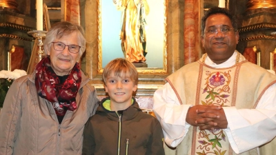 <b>Resi Haberl</b> ist 80 geworden. Aus diesem Anlass stellte sich die Mesnerin mit Pater Thomas und ihrem Enkel Silas in der Unteracher Kirche zu einem Erinnerungsfoto zusammen.  (Foto: Josef Abt)