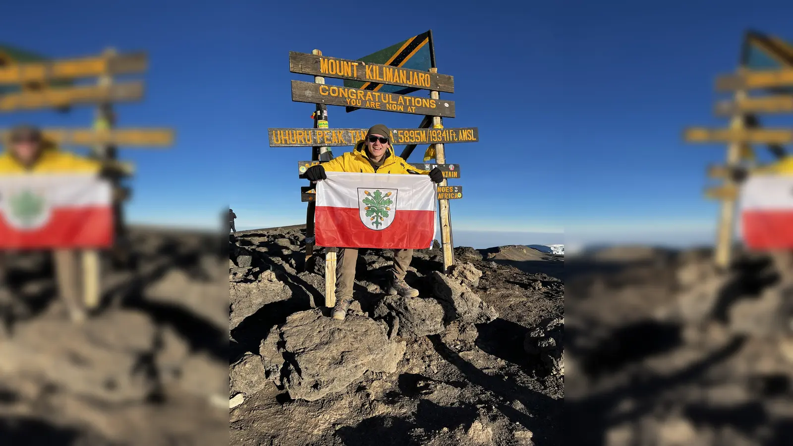 <b>Kevin Sauter</b> aus Algertshausen hat kürzlich den höchsten Berg Afrikas erfolgreich bestiegen. Oben auf dem Gipfel posierte er mit der Fahne seiner Heimatstadt.  (Foto: Kevin Sauter )