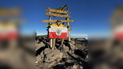 <b>Kevin Sauter</b> aus Algertshausen hat kürzlich den höchsten Berg Afrikas erfolgreich bestiegen. Oben auf dem Gipfel posierte er mit der Fahne seiner Heimatstadt.  (Foto: Kevin Sauter )