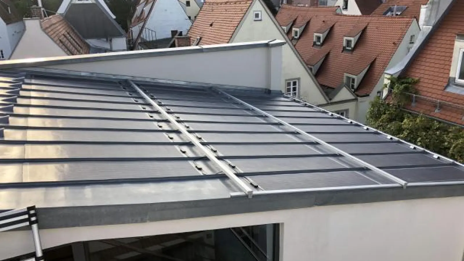 Auf dem Dach eines denkmalgeschützten   Gebäudes ist ein Photovoltaik-Laminat angebracht.