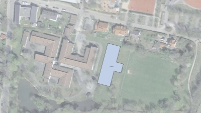 Die blaue Fläche markiert den Standort des neuen Modulbaus, wie ihn eine Machbarkeitsstudie vorschlägt. Rechts ist der Sportplatz der Berufsschule, links das bestehende Berufsschulgebäude, oben die Schulstraße.  (Foto: Projektbüro 678)
