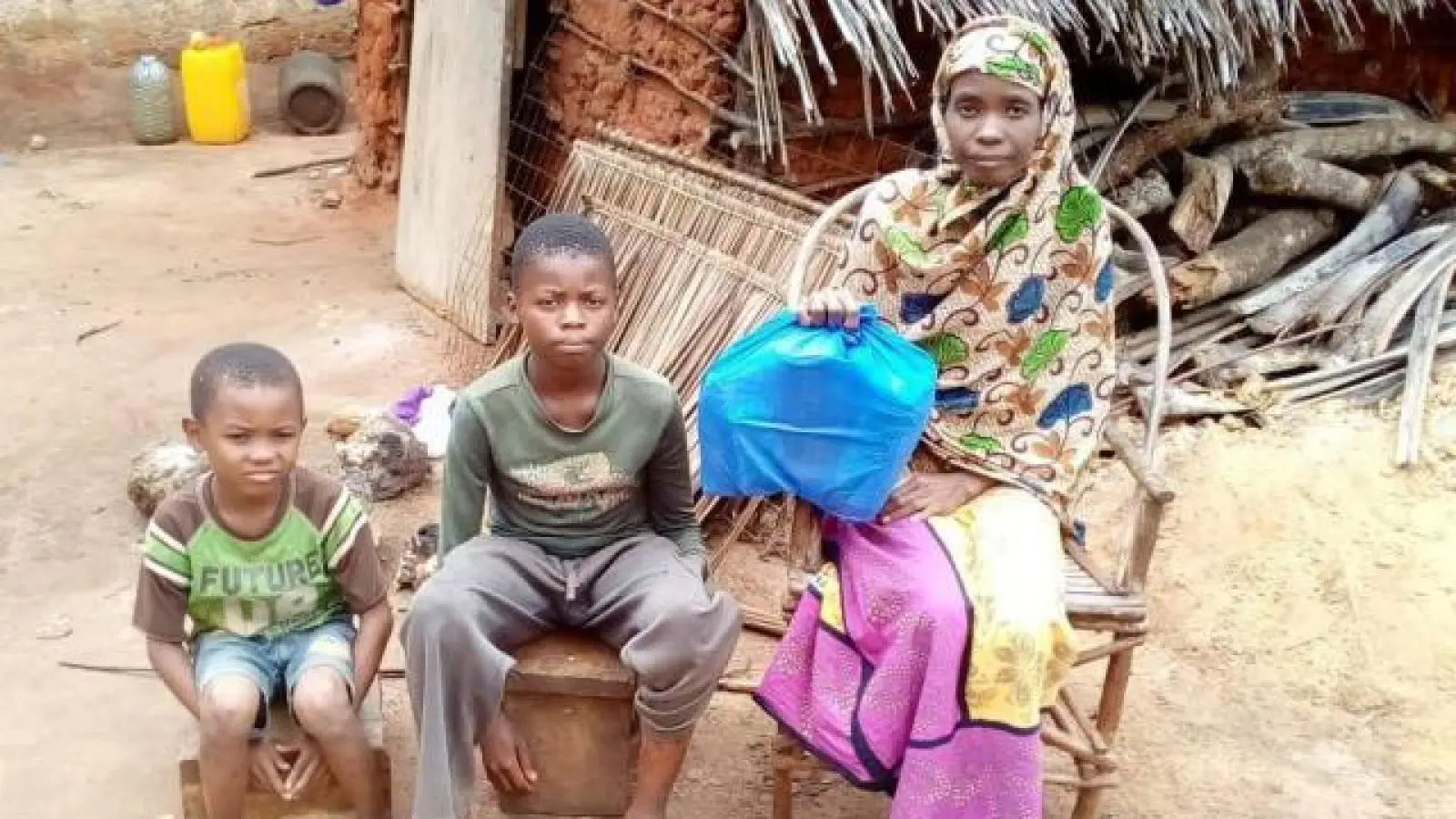 Die Witwe Amira   mit zwei ihrer vier Kinder beim Erhalt des Lebensmittelpaketes. Die Ukunda-Hilfe bittet angesichts von Corona, Regenzeit und Heuschreckenplage in Kenia um Unterstützung.