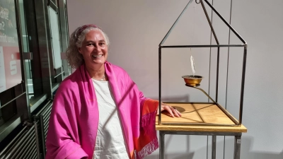<b>Die Künstlerin</b> Mandana Hanauer aus Baindlkirch stellt bis 3. November Werke in der Sparkassengalerie in Aichach aus. Hier steht sie neben einer Skulptur mit dem Titel „Harmonie und Geborgenheit”.  (Foto: Alice Lauria)