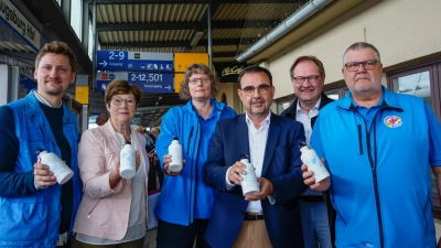 Der Bayerische Gesundheitsminister bei der symbolischen Übergabe der Trinkflaschen an die Verantwortlichen der Bahnhofsmissionen.  (Foto: mjt)